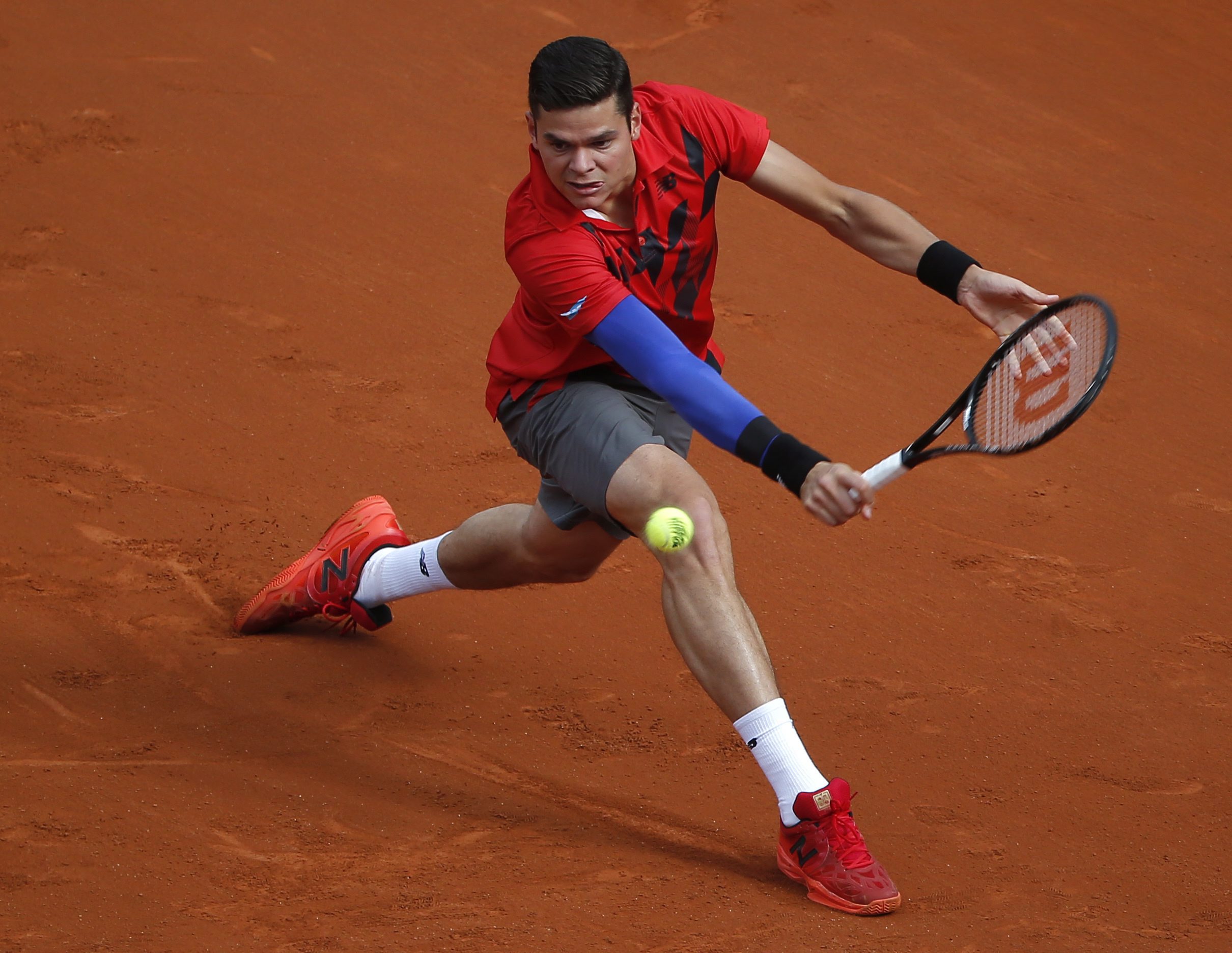 Milos Raonic effectue un revers lors de sont match de quart de finale des Internationaux de France l'opposant à Novak Djokovic, le 3 juin 2014. (AP Photo/Michel Euler)