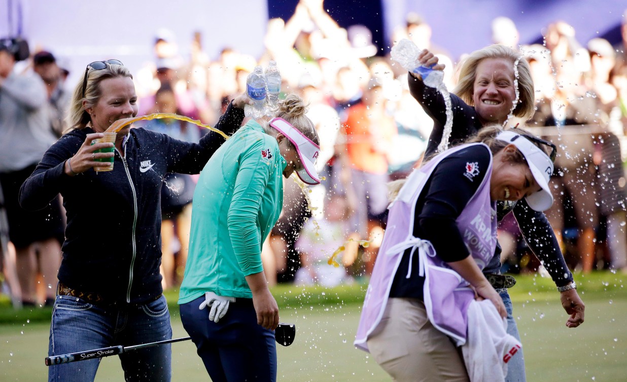 Brooke Henderson est aspergé d'eau en célébration de sa victoire. 