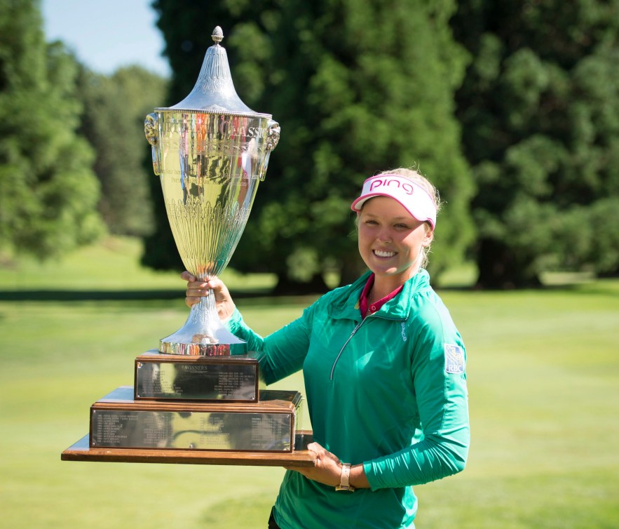 Brooke Henderson soulève un gros trophée.