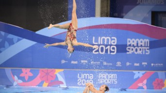 Une nageuse artistique en plein saut hors de l'eau
