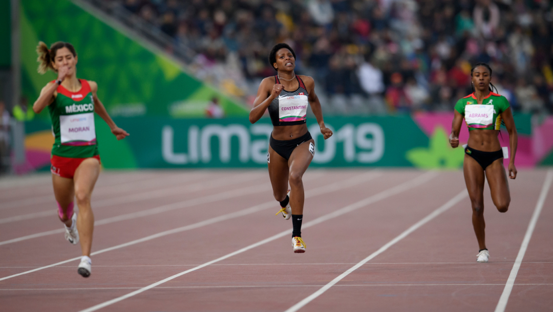 Trois athlètes courent sur le circuit d'athlétisme