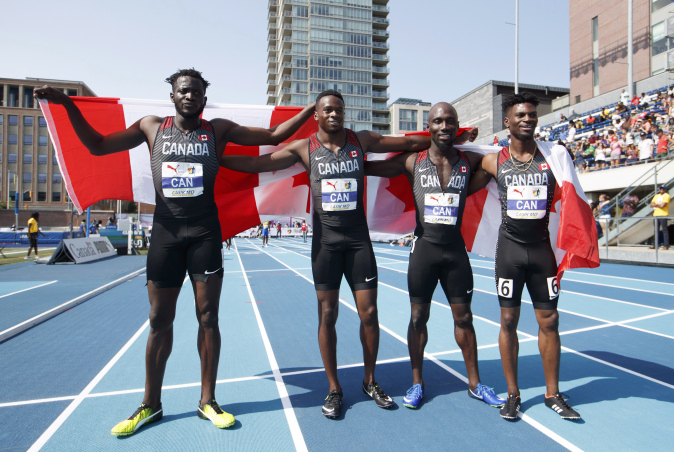 De gauche à droite, Jerome Blake, Aaron Brown, Bismark Boateng et Mobolade Ajomale posent avec le drapeau canadien après avoir remporté l'or au relais 4 x 100 m aux Championnats NACAC à Toronto, le 12 août 2018. LA PRESSE CANADIENNE/Mark Blinch
