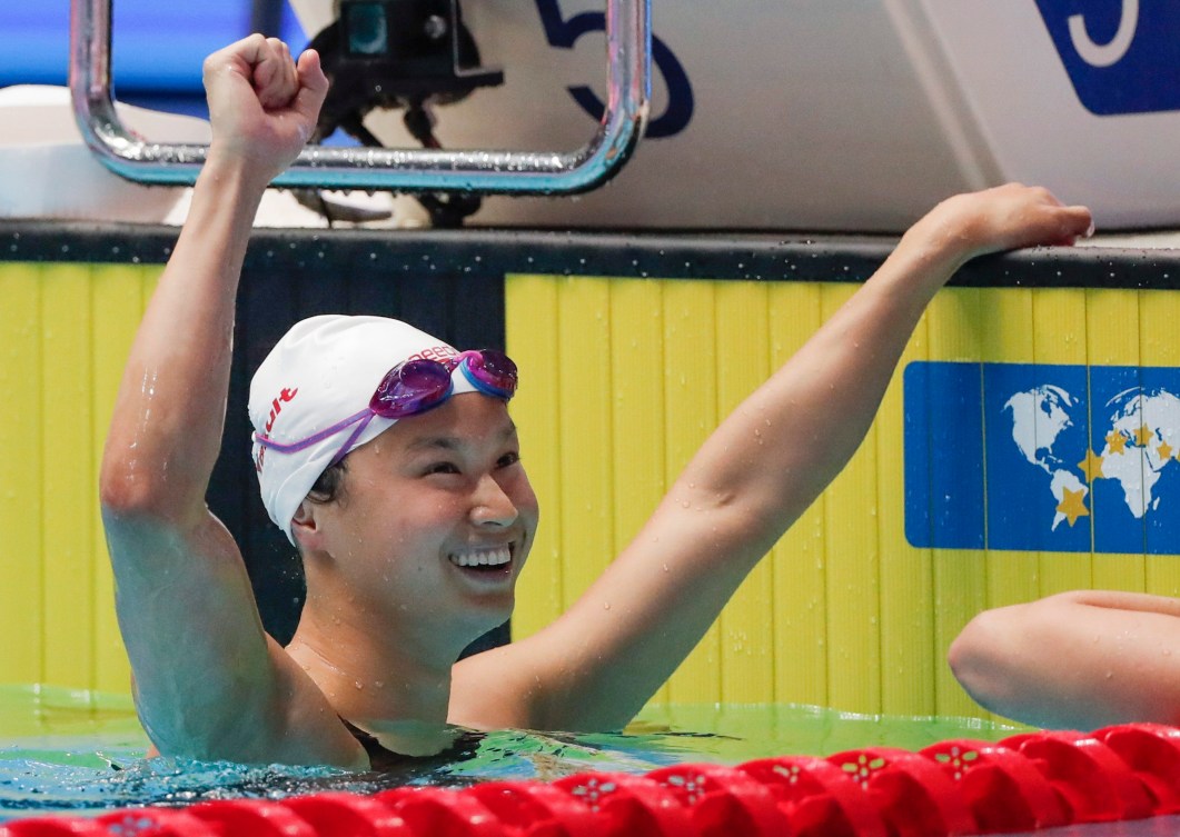 La nageuse Maggie Mac Neil lève le bras dans les airs après sa victoire aux Championnats du monde FINA 2019. 