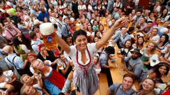 Une femme célèbre le début de l'Oktoberfest à Munich avec une bière à la main