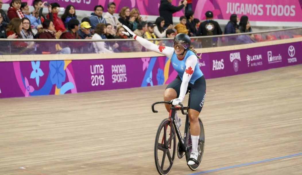 Kelsey Mitchell souriante sur son vélo après avoir remporté une médaille.