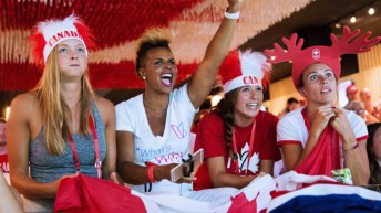 Quatre spectatrices encouragent Équipe Canada à la Maison olympique du Canada à Rio 2016.