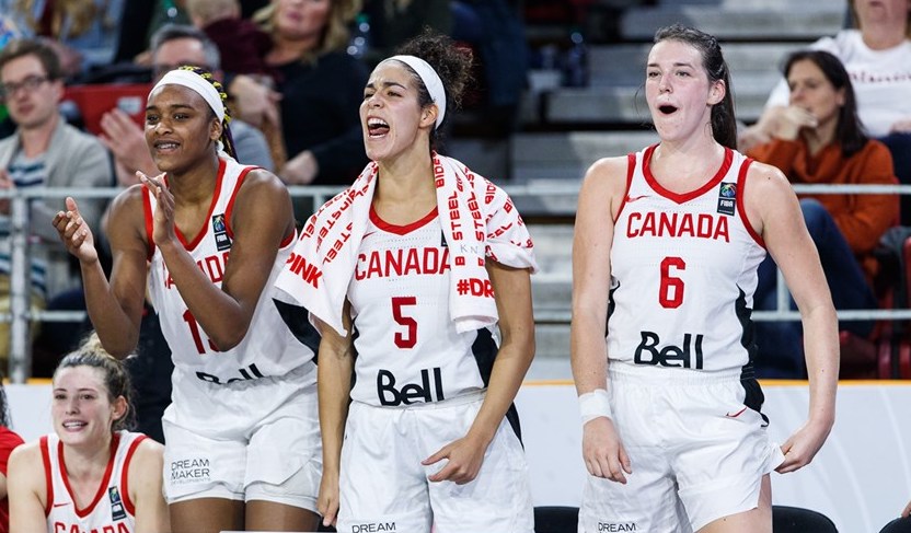 Trois joueuses canadiennes encouragent leurs coéquipières du banc