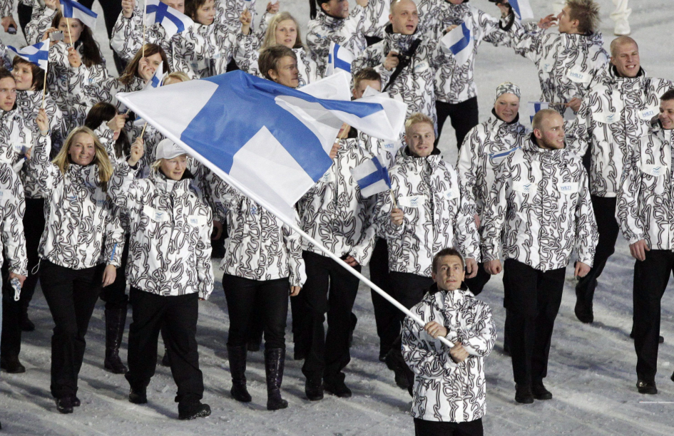 Le porte-drapeau de la Finlande et son équipe entrent dans le stade