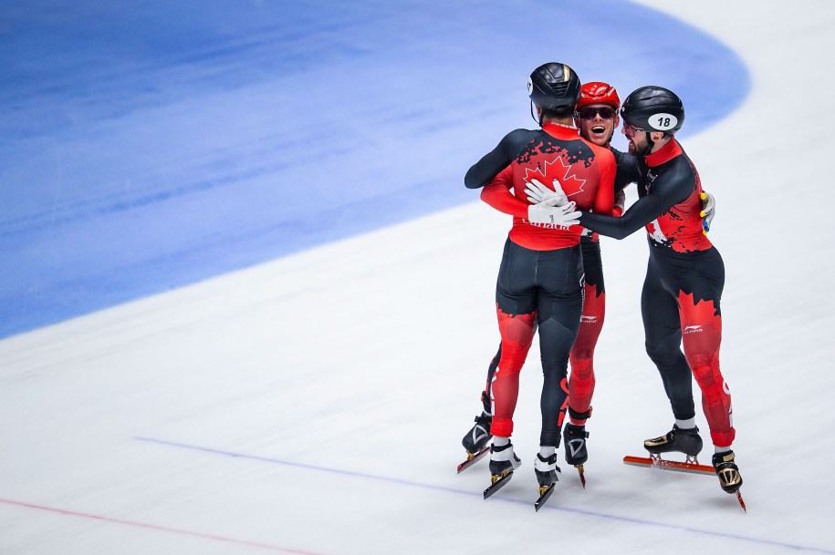 Trois patineurs canadiens se serrent dans leurs bras