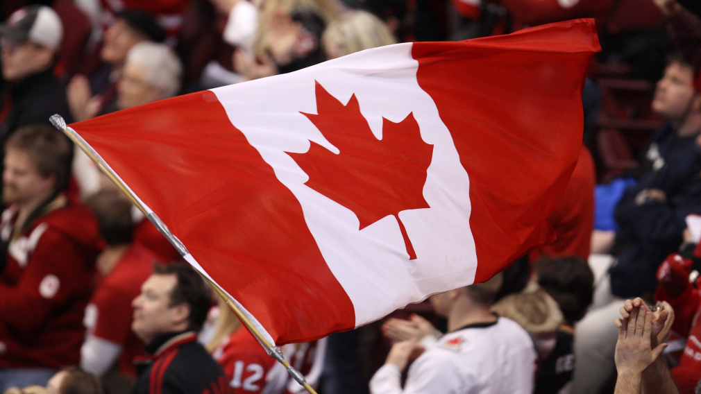 UN drapeau canadien flotte dans la foule lors d'un match de hockey de Vancouver 2010