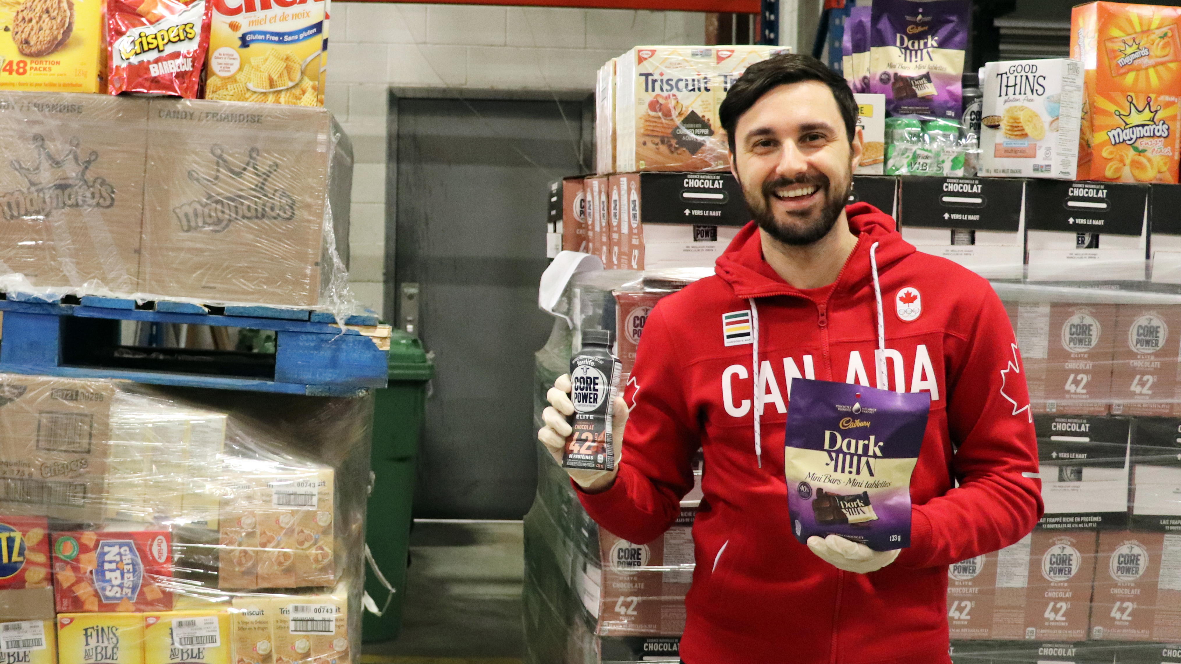 Joseph Polossifakis pose avec le lait au chocolat protéiné Core Power et les chocolats Dark Milk. (MOISSON MONTRÉAL/ALEXANDRA GRENIER)