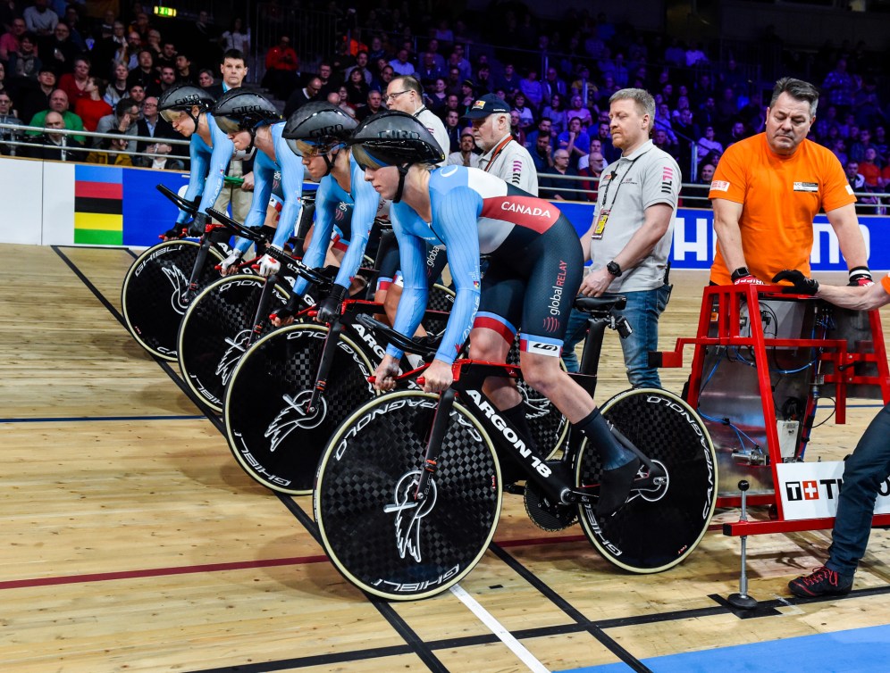 Quatre cyclistes sur la ligne de départ dans un vélodrome