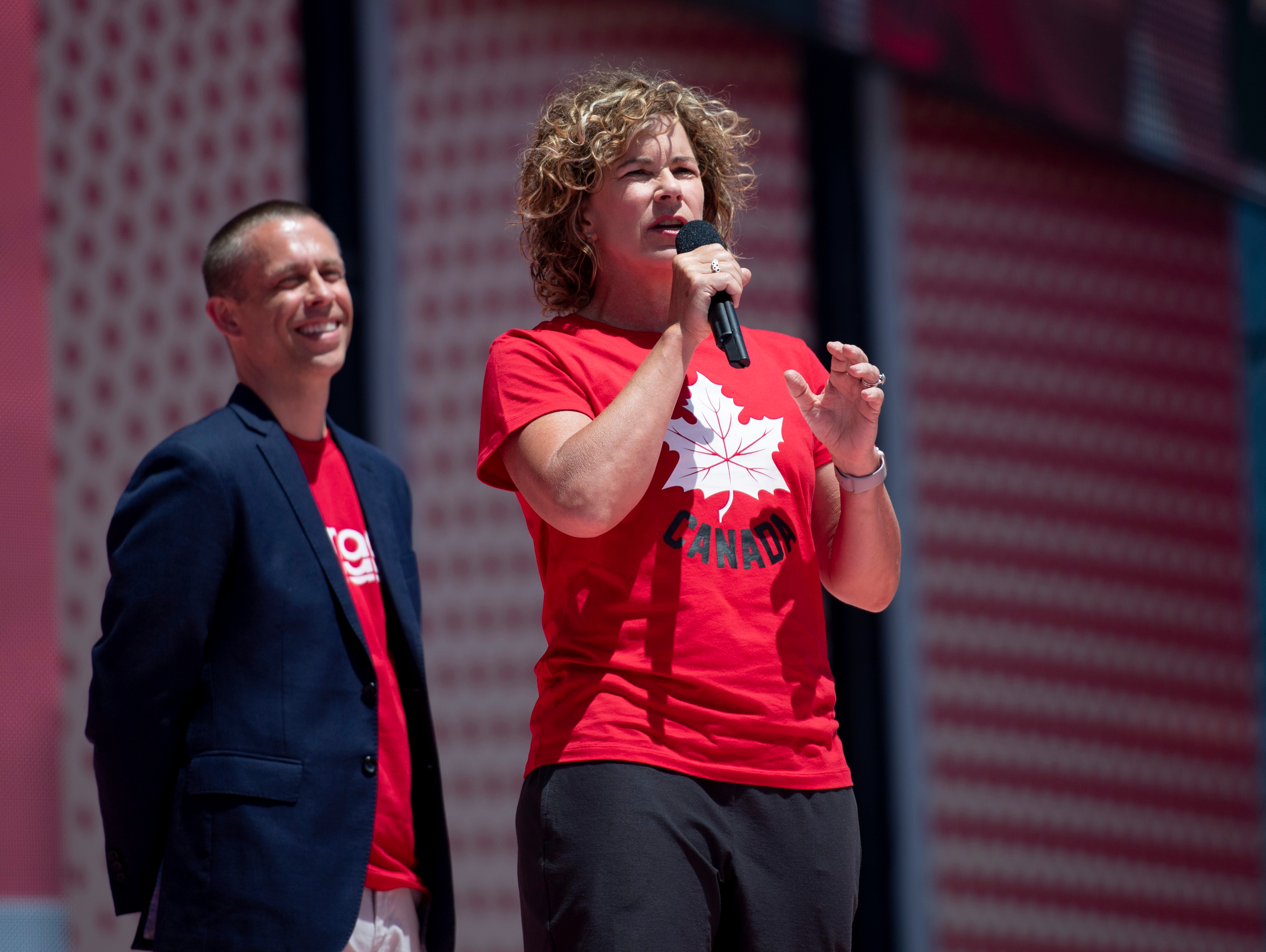 Marnie McBean s'adresse à une foule avec un micro en main.