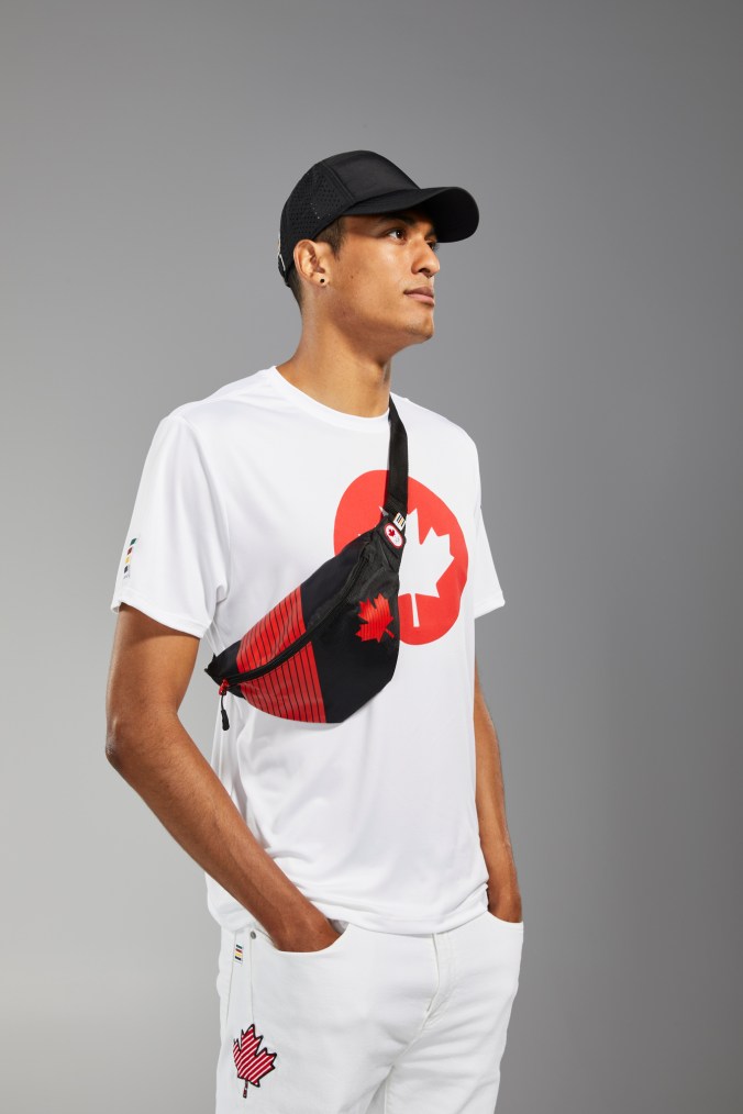 Pierce LePage porte un t-shirt blanc, un sac banane, une casquette noire et des jeans blancs