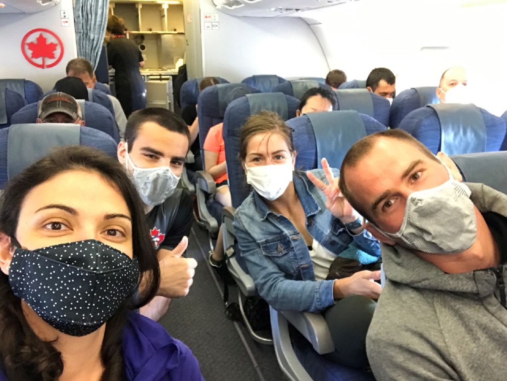 Léquipe canadienne de judo portant son masque, à bord dun avion