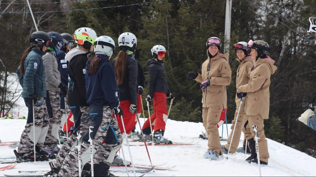 Maxime, Chloé et Justine Dufour-Lapointe pendant une séance d'explications lors d'un camp de développement avec des jeunes skieurs.