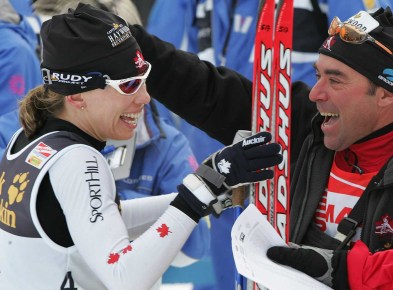 Une skieuse et un technicien célàbrent une victoire