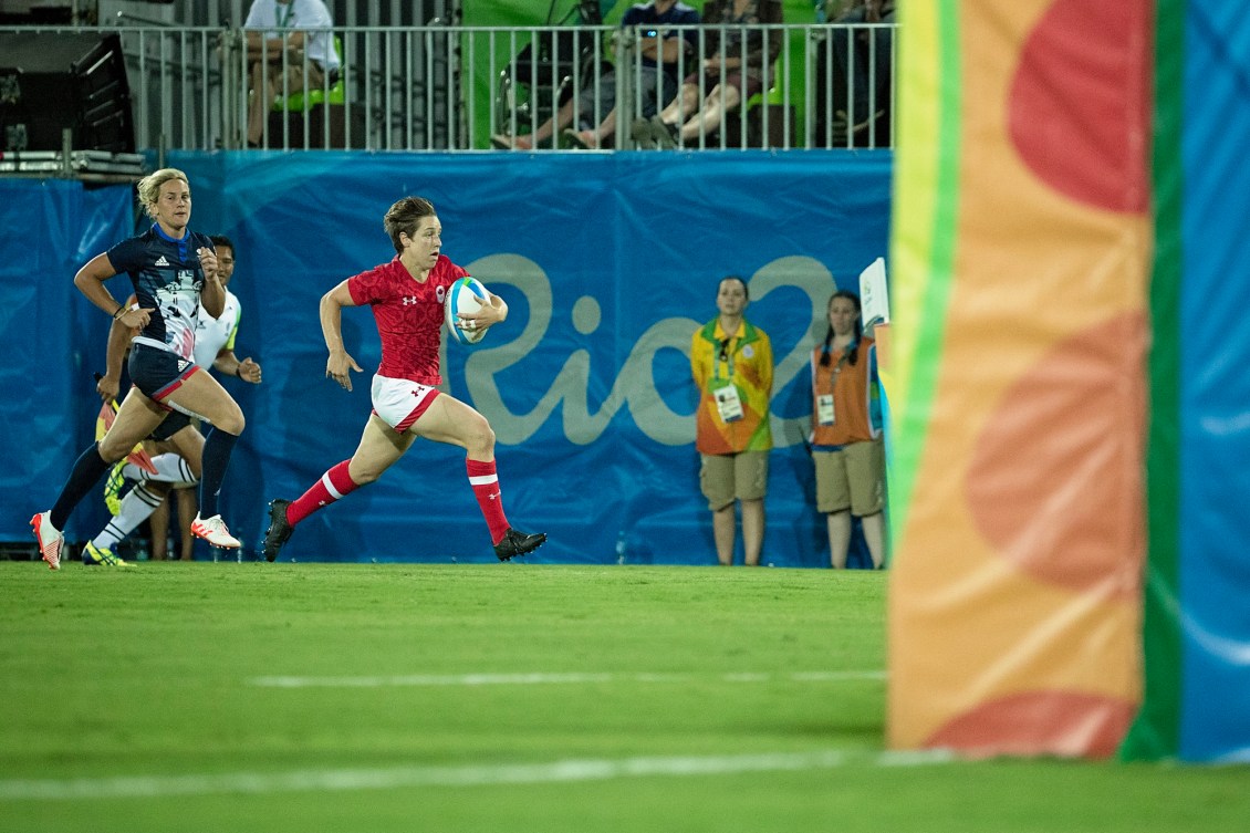 Une joueuse de rugby court avec le ballon