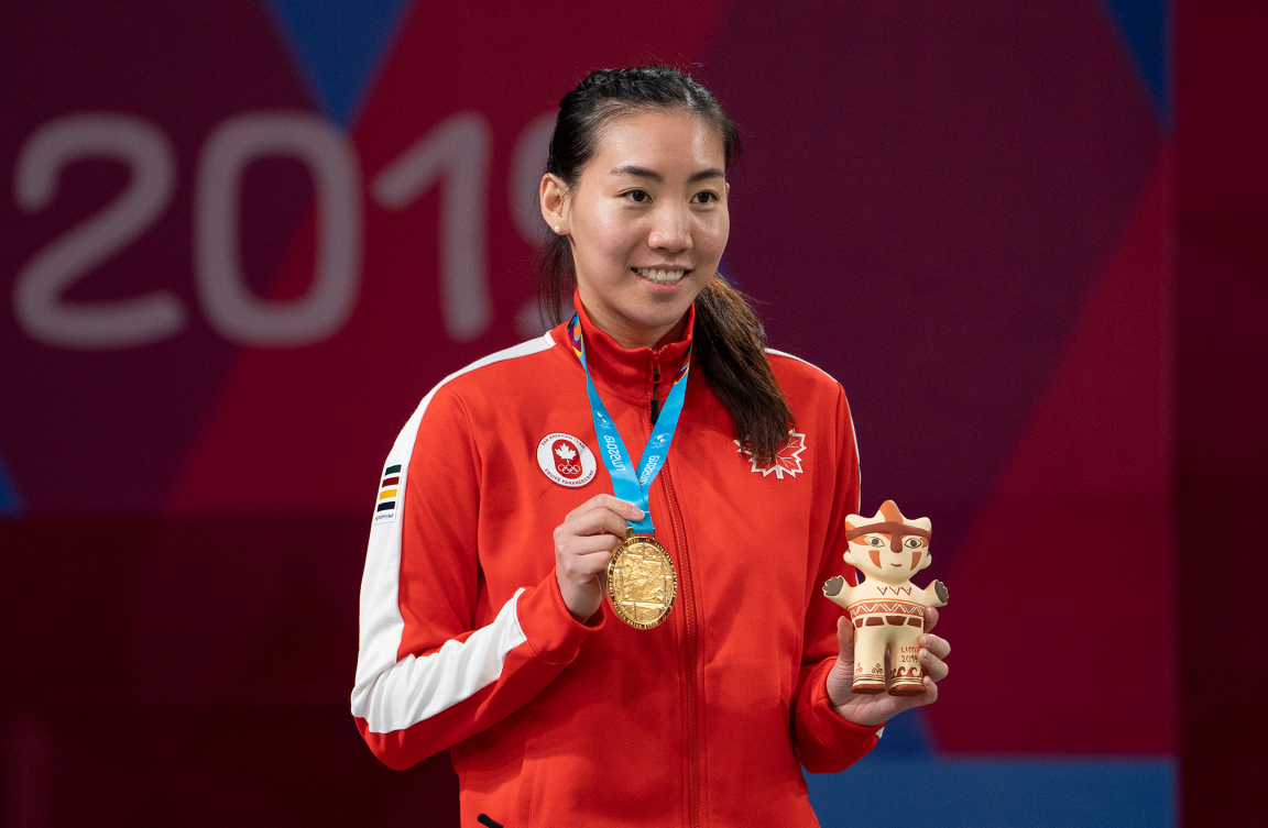 Une athlète de badminton montre sa médaille d'or