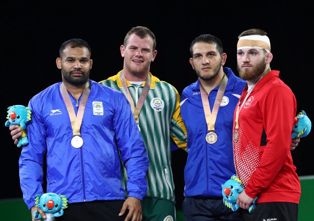 Les médaillés de lutte posent pour les photographes avec leur médaille. 