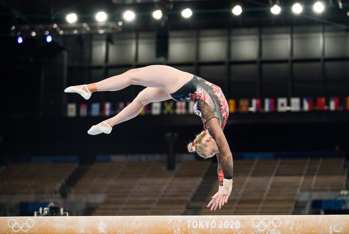 Une gymnaste performe à la poutre.