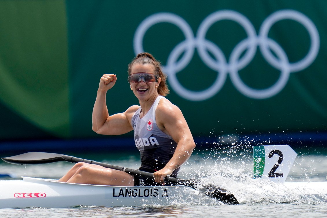 Andréanne Langlois lève le poing dans les airs pour célébrer après une course de kayak.