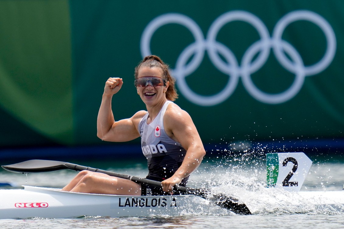 Andréanne Langlois raises her fist in the air to celebrate after a kayak race.