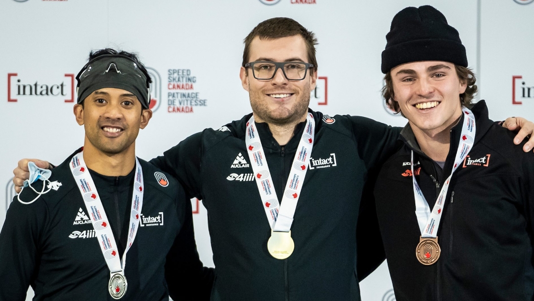 Trois patineurs posent avec leur médaille au cou.