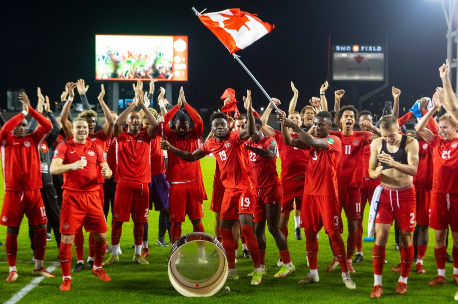 Les joueurs de soccer d'Équipe Canada célèbrent sur le terrain en posant pour la caméra.