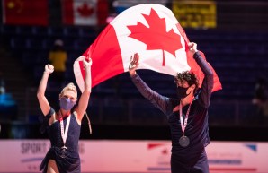 Piper Gilles et Paul Poirier tiennent le drapeau canadien avec leur médaille d'or au cou.