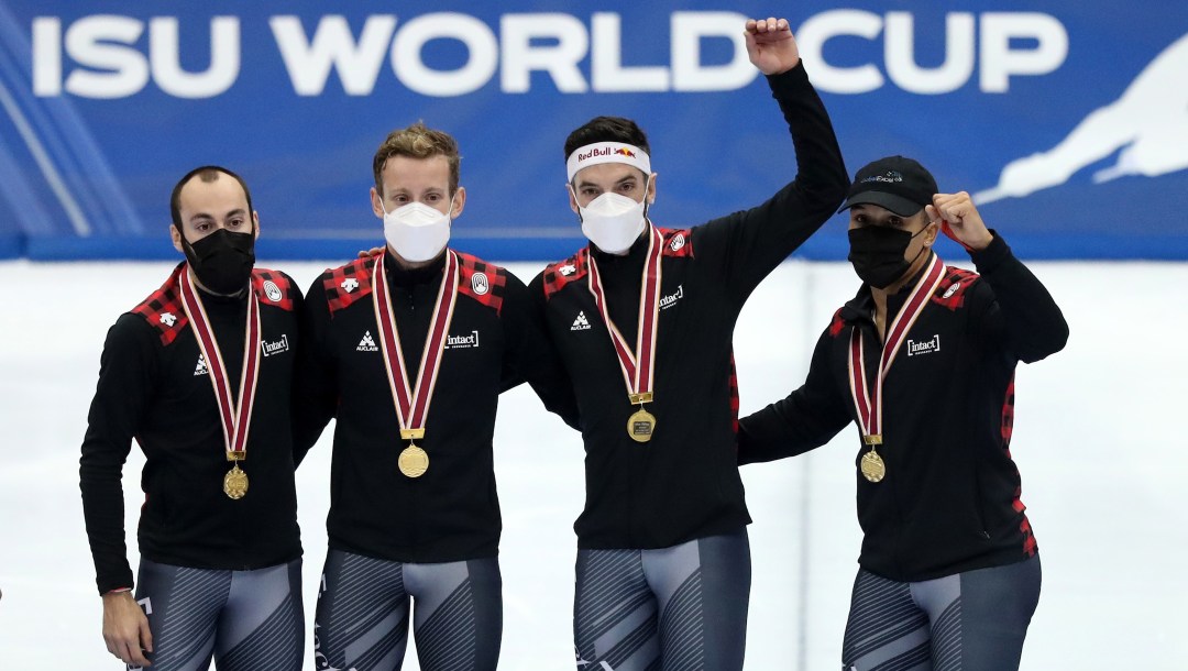 Les quatre patineurs sur le podium avec leur médaille d'or autour du coup.