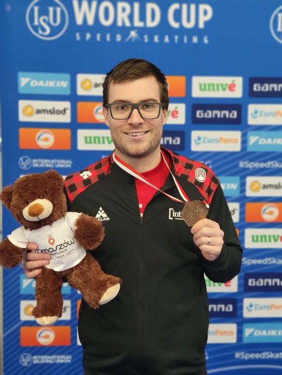 Laurent Dubreuil avec une médaille de bronze autour du cou et un ourson en peluche dans la main droite.