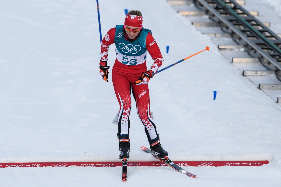 Une skieuse franchie la ligne d'arrivée.