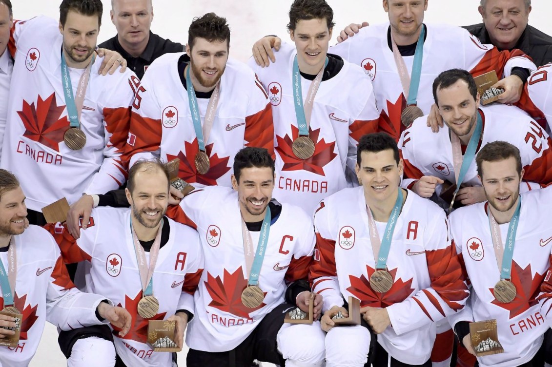 Des joueurs de hockey avec la médaille d'or autour du cou.