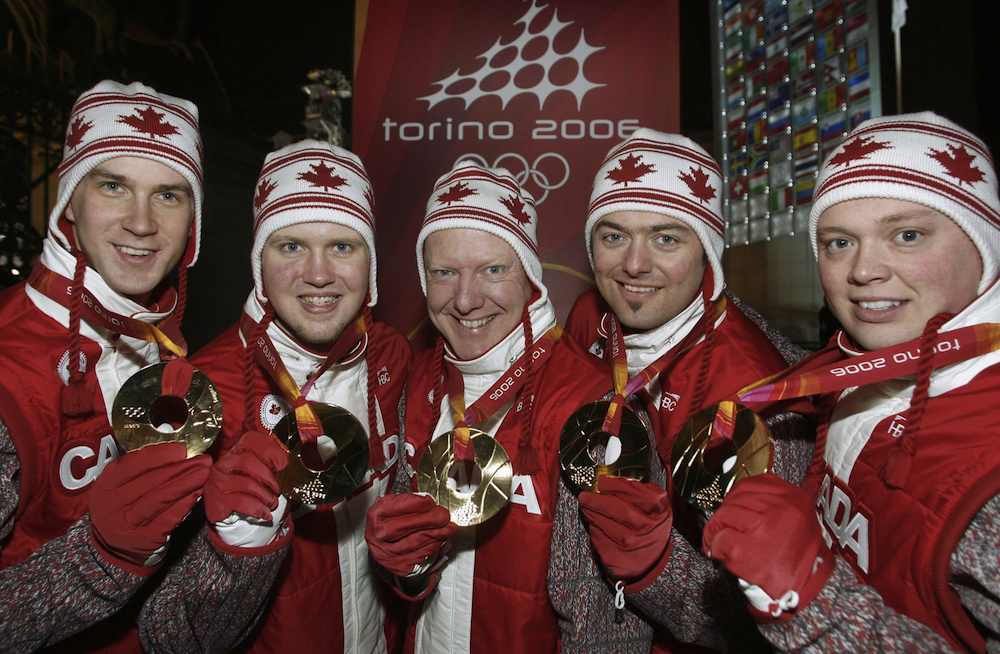 Cinq athlètes avec leur médaille d'or autour du cou.