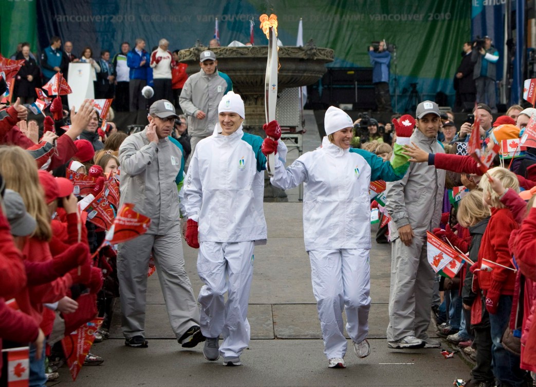 Catriona Le May Doan, à droite, et Simon Whitfield portent le flambeau olympique de Vancouver 2010.