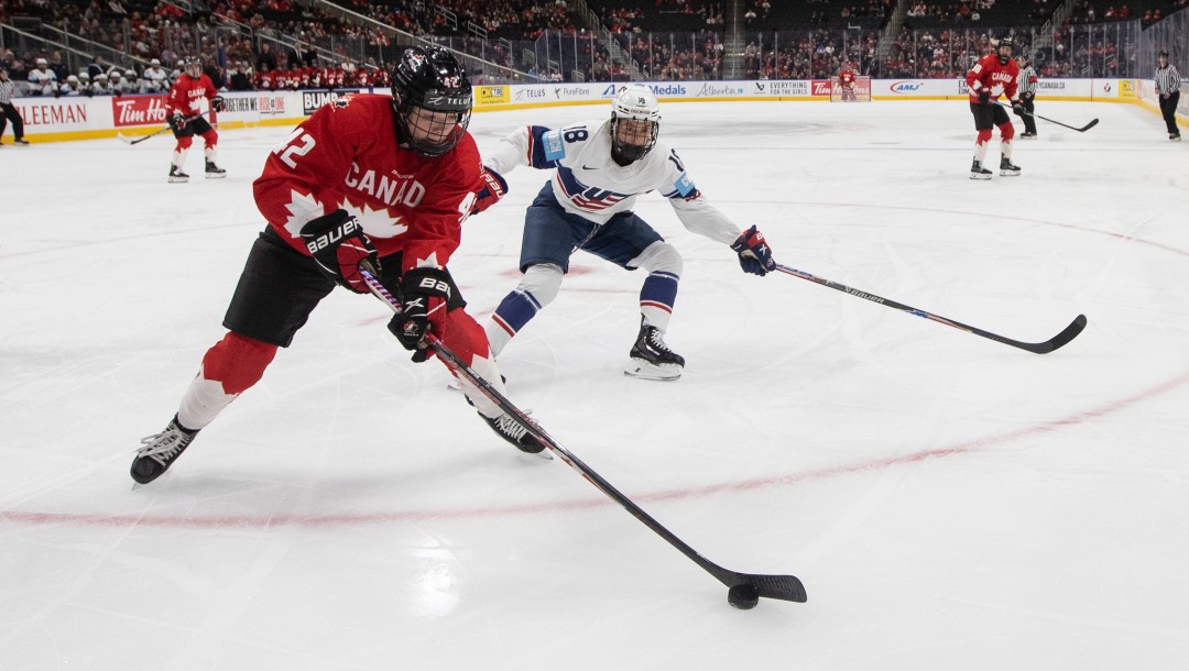 Claire Thompson protège la rondelle dans le coin de la patinoire.