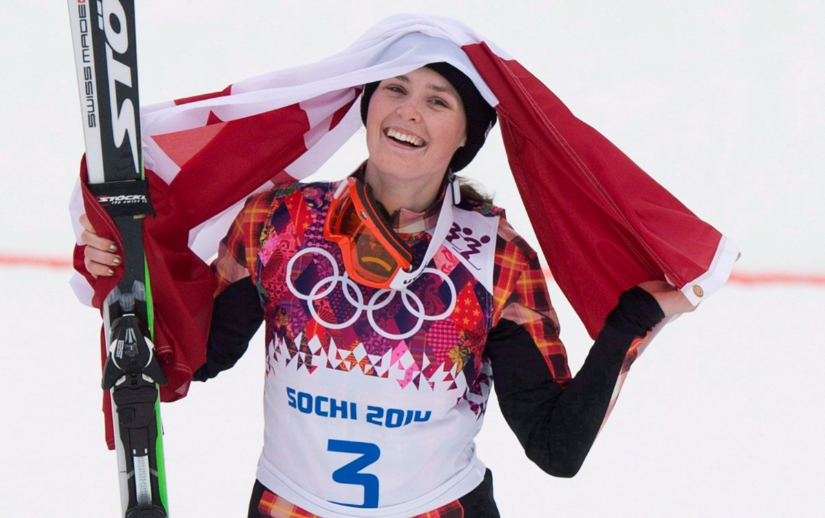 Une skieuse célèbre sa victoire avec le drapeau du Canada