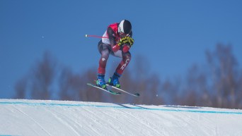 Un skieur en plein saut lors d'une descente de ski cross