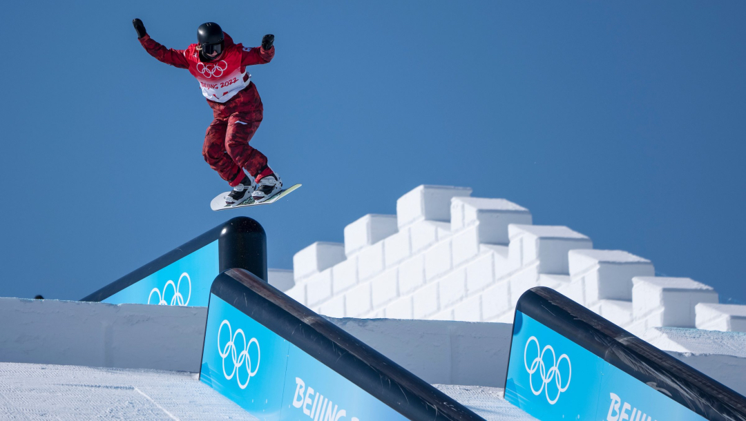 Une athlète de snowboard effectue un saut sur la rampe de slopestyle