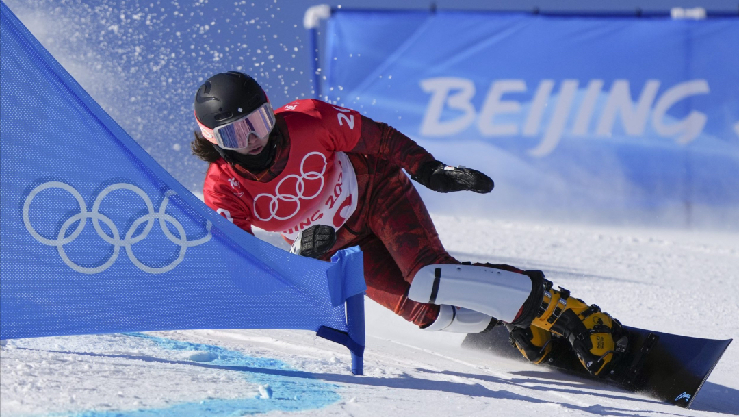 Une athlète de snowboard dévale la pente à toute vitesse