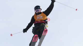 Une skieuse effectue une manoeuvre en slopestyle