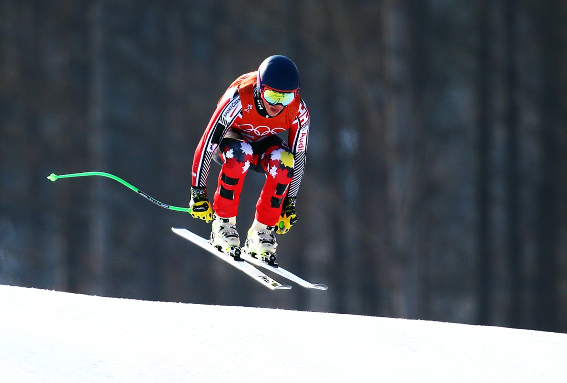 Un skieur fait un léger saut lors de sa descente de ski alpin