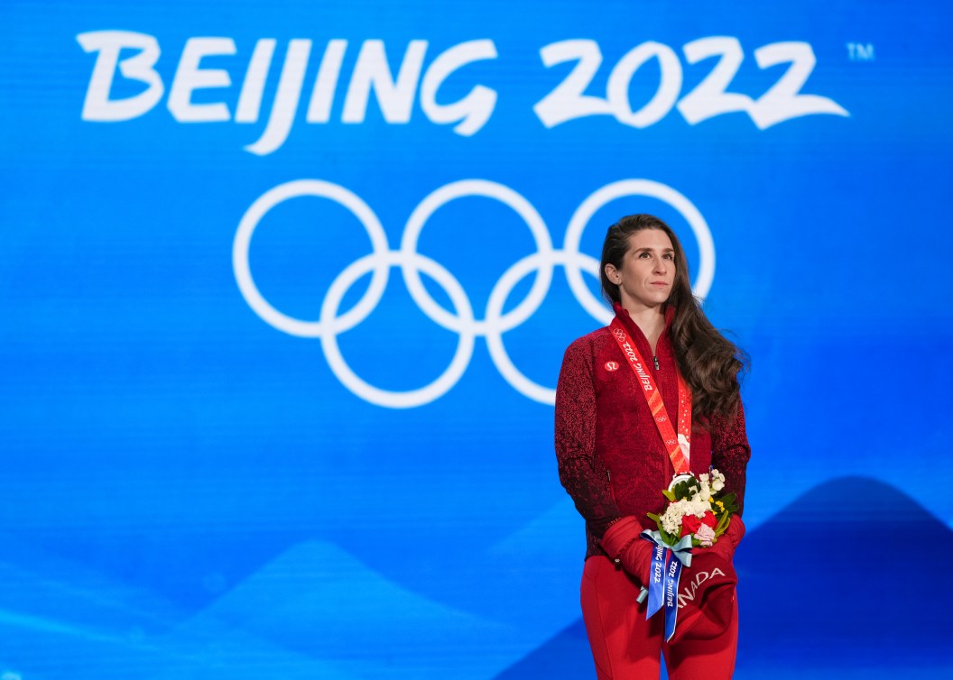 Ivanie Blondin sur le podium sa médaille d'argent au cou, ses fleurs dans les mains. 