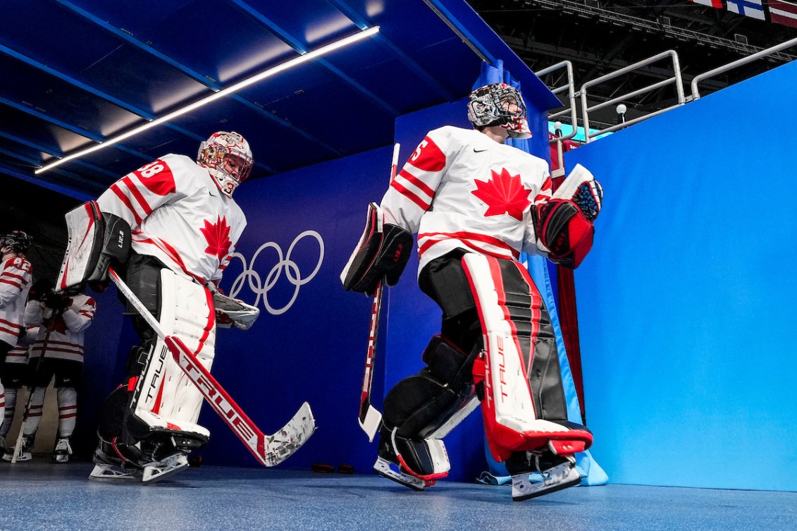 La gardienne de but d'Équipe Canada Ann-Renée Desbiens marche dans le corridor vers la patinoire suivie des autres joueuses de l'équipe de hockey à Beijing 2022.
