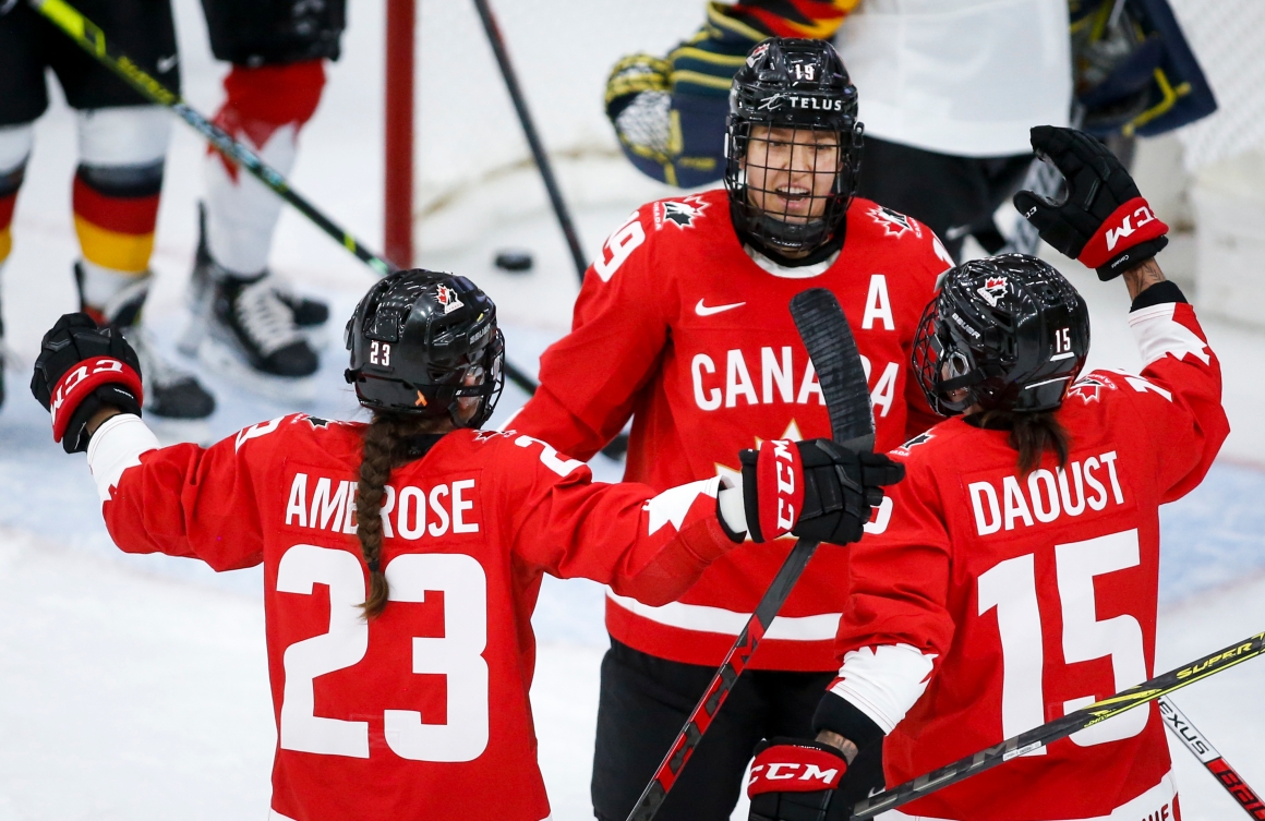 Trois hockeyeuses célébrant après un but