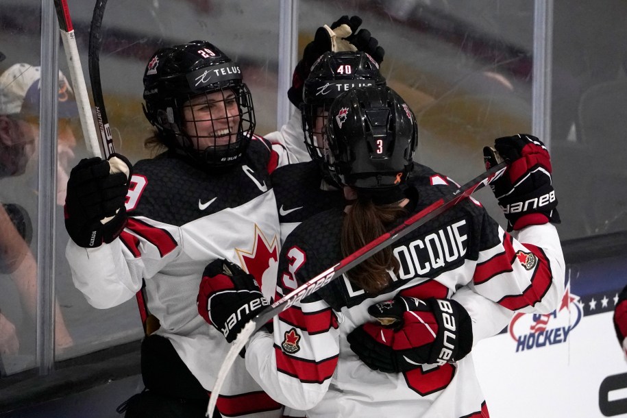 Trois hockeyeuses célébrant après un but