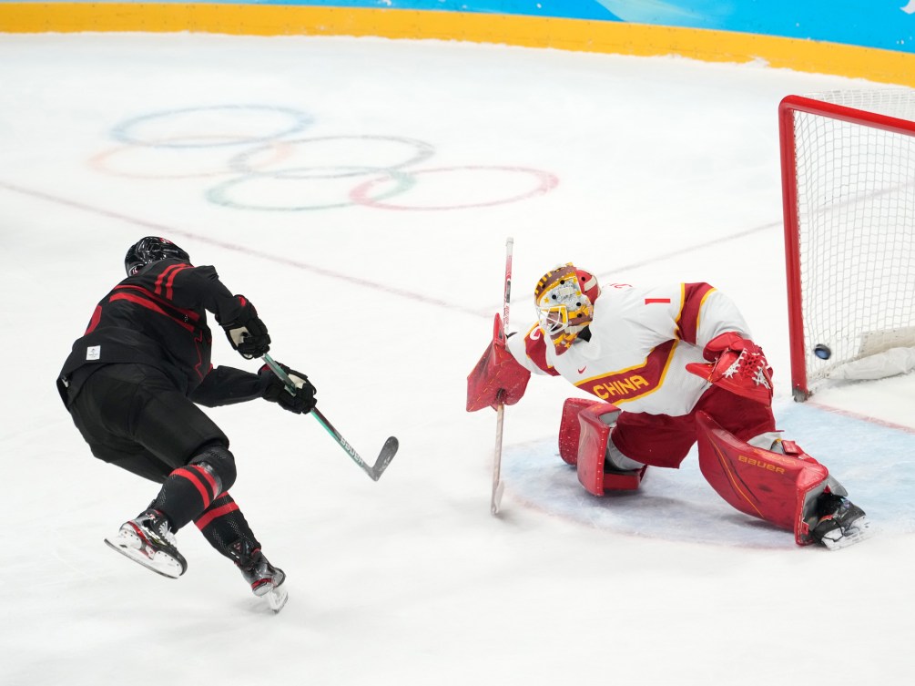 Adam Tambellini marque un tir de pénalité face au gardien de but de l'équipe chinoise Paris O'brien lors du match de qualification du tournoi de hockey masculin à Beijing 2022