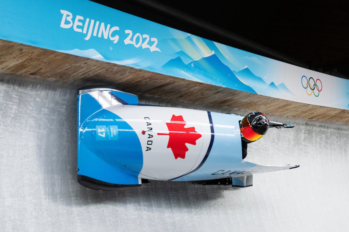 Cynthia Appiah d'Équipe Canada prend un virage dans son monobob et touche presque le mur de droite qui est à l'horizontal, à Beijing 2022.