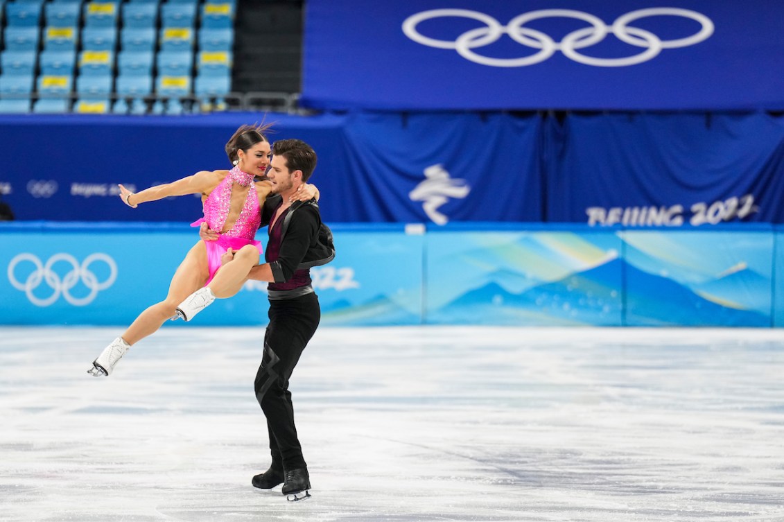 Nikolaj Soerensen tient sa partenaire Laurence Fournier Beaudry par une cuisse et la taille lors d'une figure en danse rythmique au patinage artistique de Beijing 2022